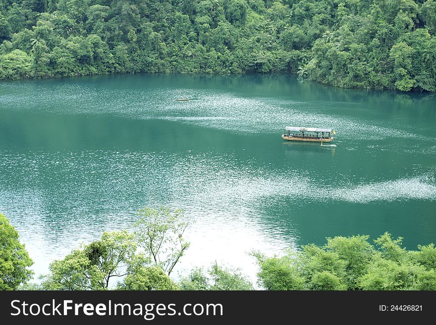 A small boat on blue water. It is a lake in the mountain valley, the water is in blue color.