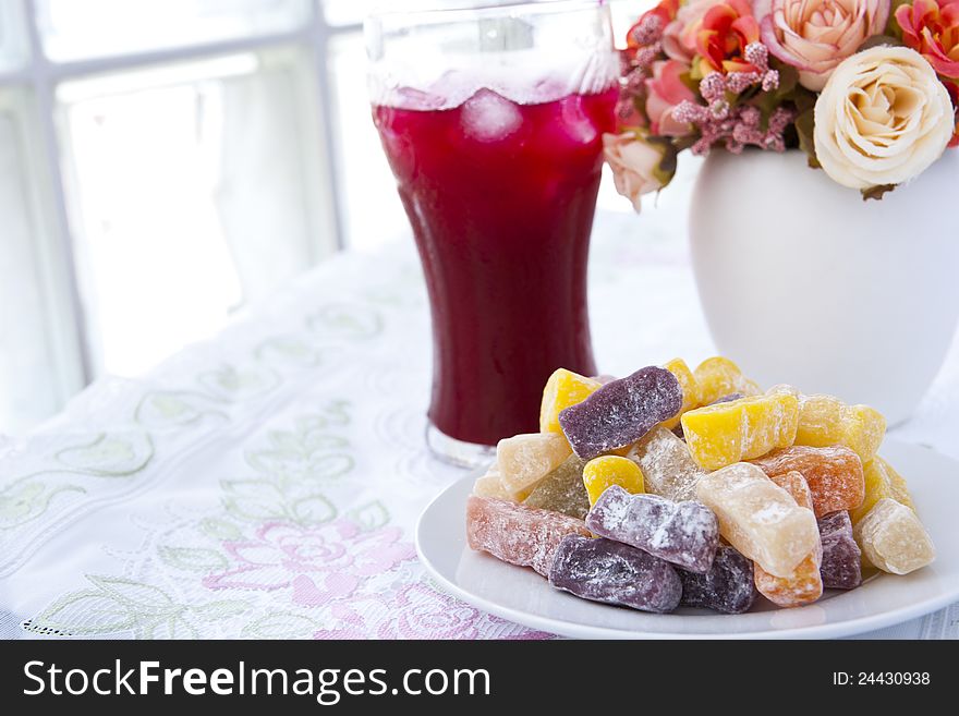 Colorful fruit jelly candy on white plate with juice. Colorful fruit jelly candy on white plate with juice