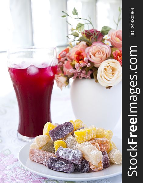 Colorful fruit jelly candy on white plate with juice. Colorful fruit jelly candy on white plate with juice