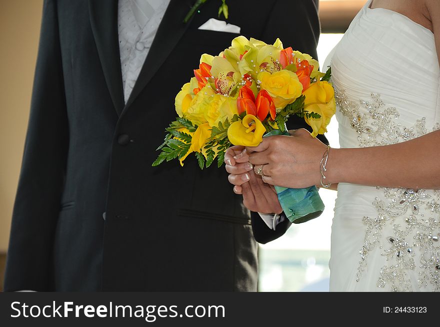 Bride and groom holding floral wedding bouquet