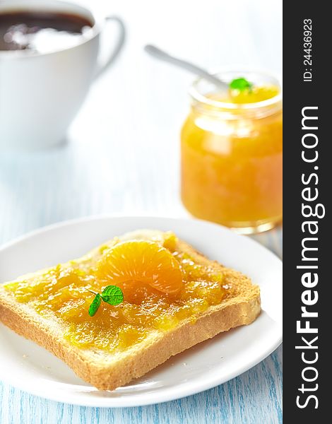 Toast with mandarin marmalade, slice fresh fruit, mint and coffee for breakfast. Toast with mandarin marmalade, slice fresh fruit, mint and coffee for breakfast