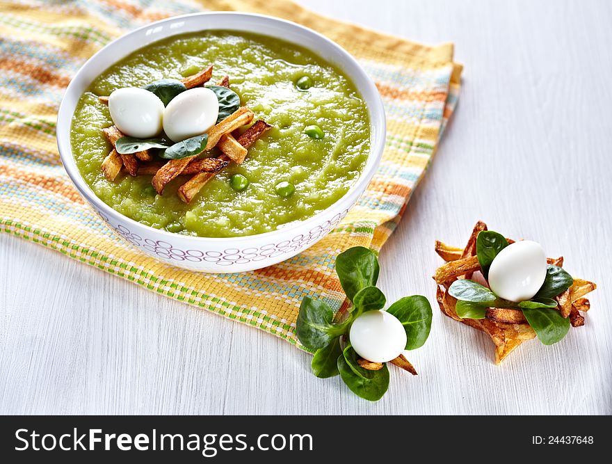 Green broccoli pea soup with vegetable nest and eggs for easter dinner