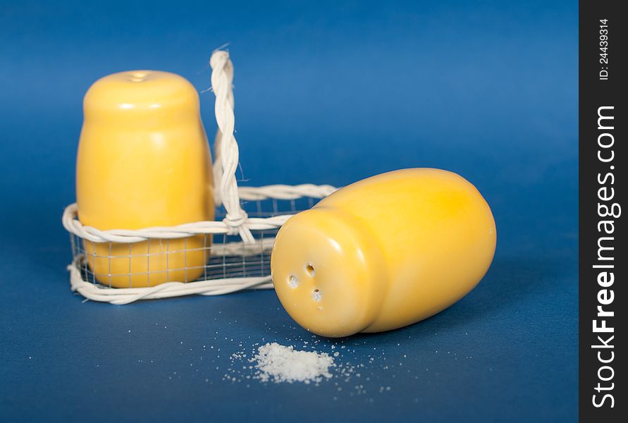 Yellow ceramic salt shaker on a blue background