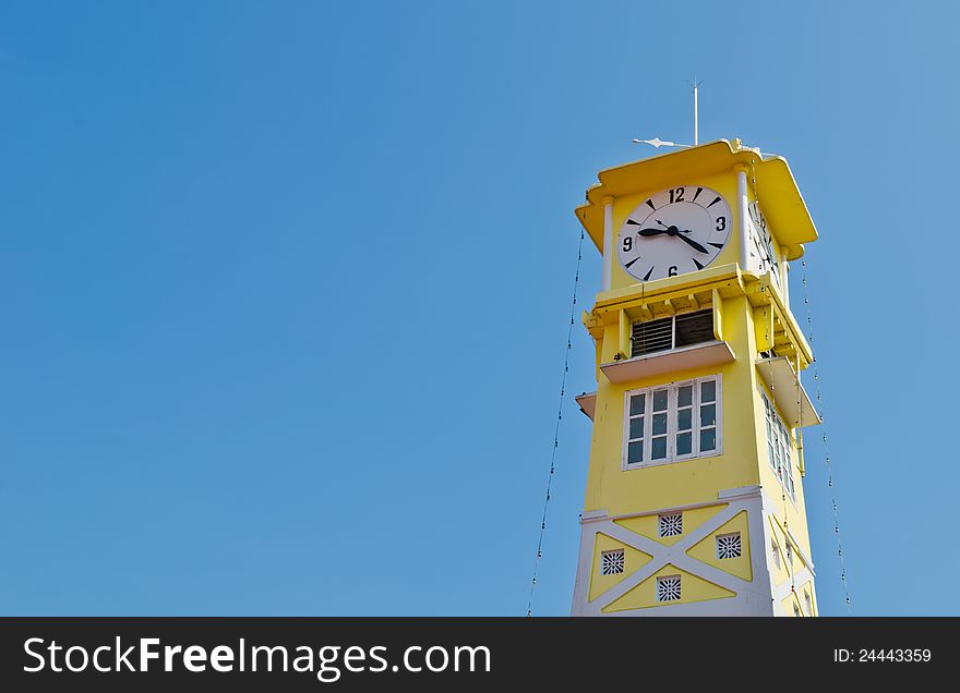 Old yellow clock tower  with blue sky at Ratchaburi ,Thailand. Old yellow clock tower  with blue sky at Ratchaburi ,Thailand