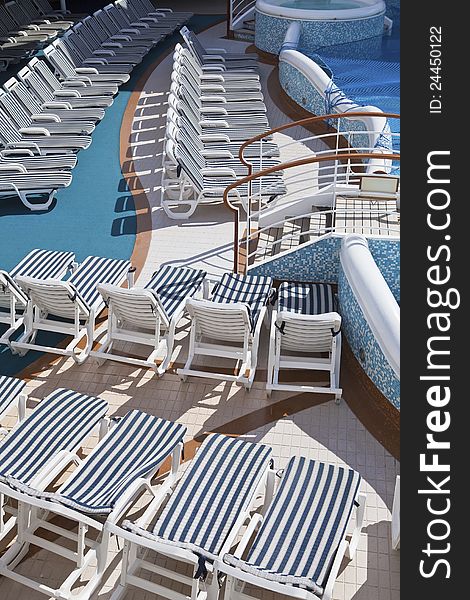 Roe of striped deck chairs on sundeck of the cruise ship on sunny day. Roe of striped deck chairs on sundeck of the cruise ship on sunny day