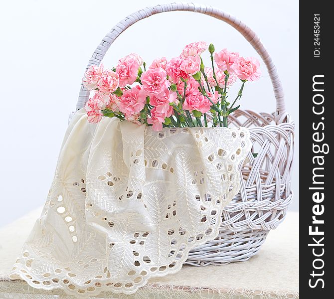 Delicate pink carnations in a white wicker basket. Delicate pink carnations in a white wicker basket