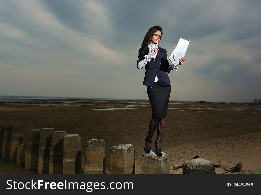 Business lady standing on the beach, on a backgrou