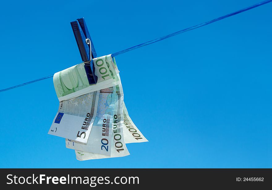 Concept of money hanging on clothesline against blue sky. Concept of money hanging on clothesline against blue sky