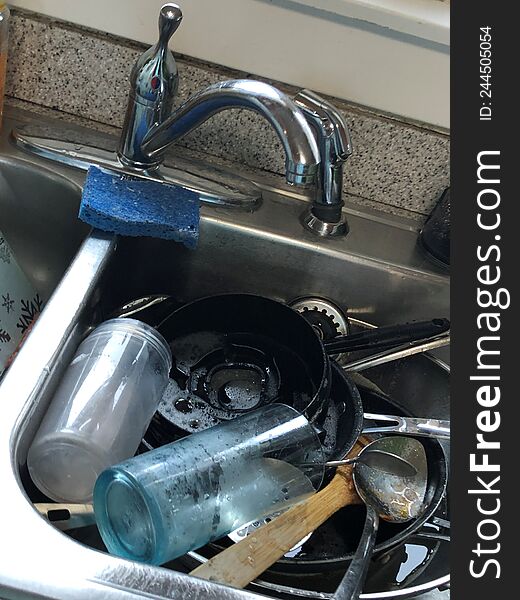 Housekeeper duties, sink full of dirty unwashed dishes, cups, plates, silverware, serving utensitls, pans, pots,  double sink,. Housekeeper duties, sink full of dirty unwashed dishes, cups, plates, silverware, serving utensitls, pans, pots,  double sink,