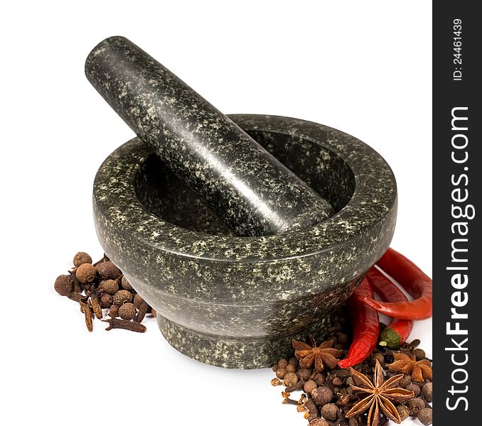 Stone mortar with spices and chilli on a white background