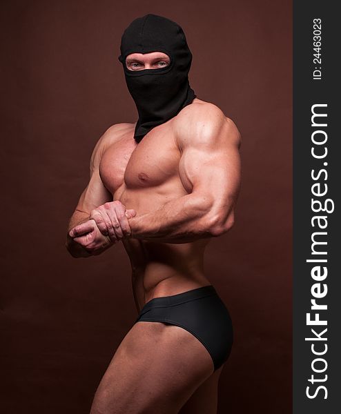 Bodybuilder in a mask showing his muslces. Bodybuilder in a mask showing his muslces