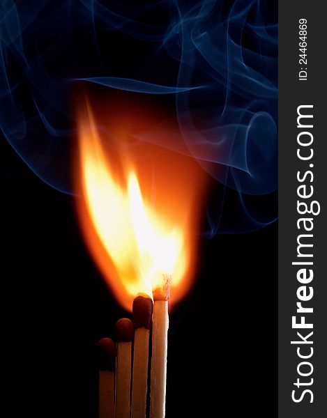 Burning matchstick on black background