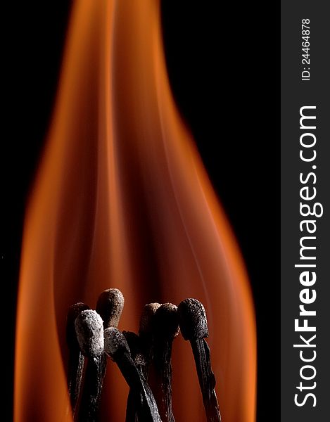 Burning matchstick on black background