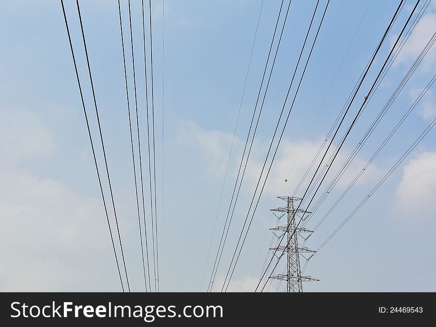 High voltage electrical power wire and post in the blue cloud sky