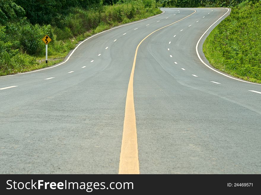 High way curve road with sign and tree on the side