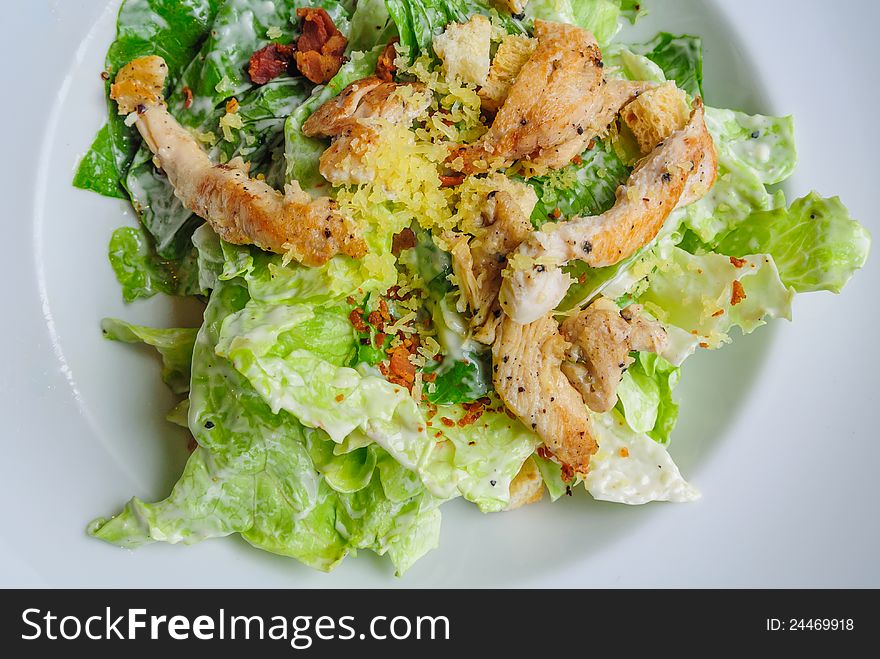 Close up top view of roast chicken salad in white plate