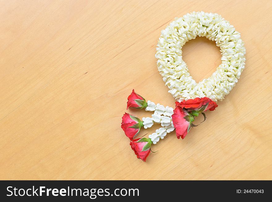 Traditional thai style white and red flower garland on wood background. Traditional thai style white and red flower garland on wood background