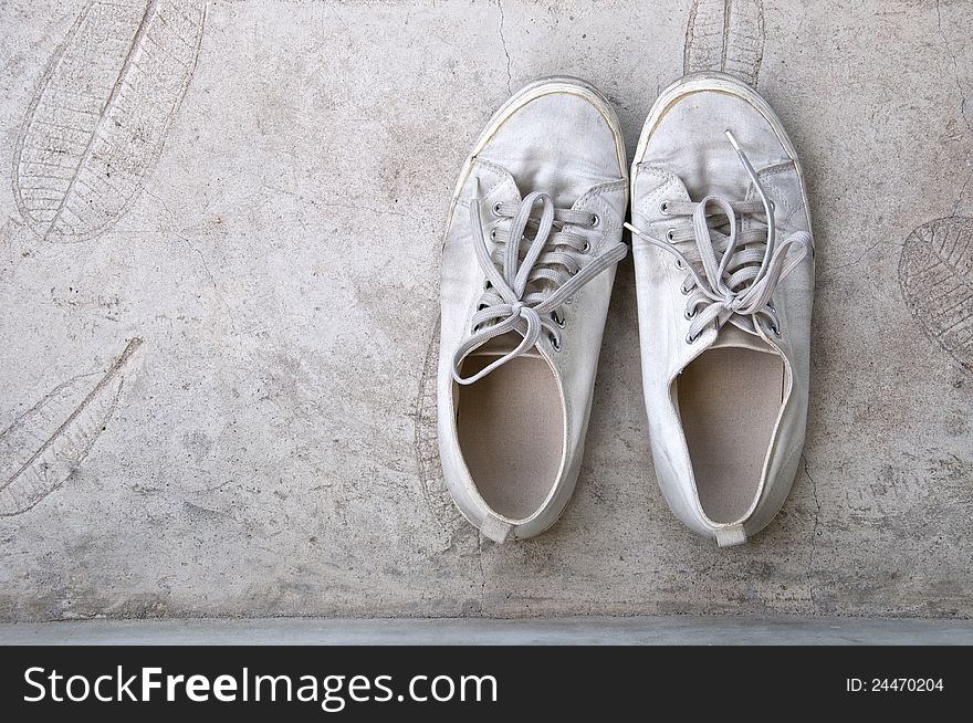 Old white sneaker on cement floor