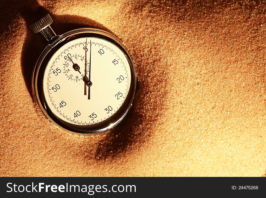 Closeup of old stopwatch on sand surface with free space for text