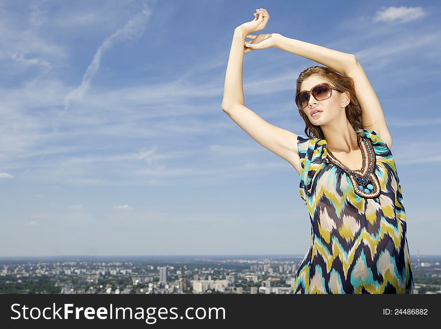 Portrait of beautiful brunette girl in sunglasses on background blue sky. Portrait of beautiful brunette girl in sunglasses on background blue sky