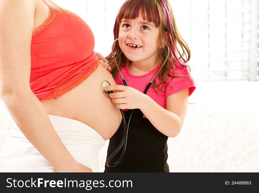 Girl listening to the baby in the mother's abdomen