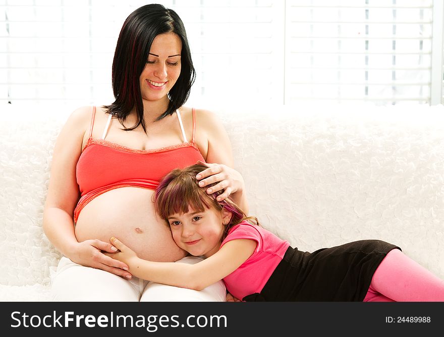 Pregnant mother and daughter sitting together