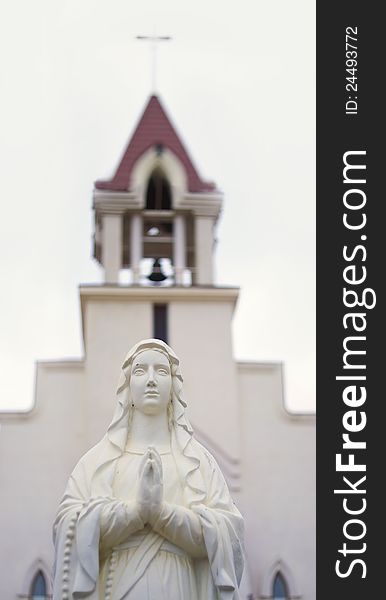 Statue on white background with church