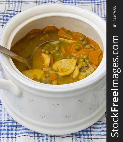 Vegetable soup with green peas, carrot and pasta in white bowl