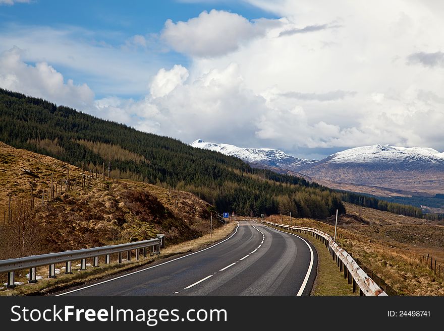 Empty Countryside Road Highway of Highlands Scotland with Beautiful Snow Mountain Range