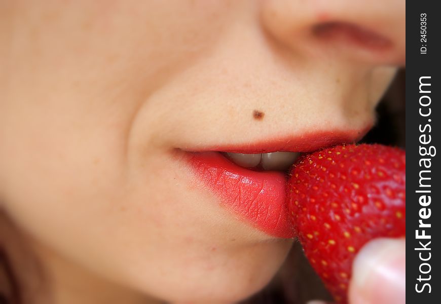 Picture of a girl tasting a strawberry. Picture of a girl tasting a strawberry