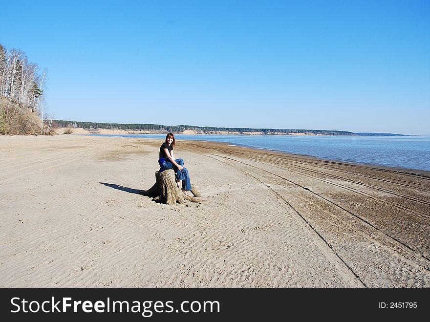 Gril sitting on the snag and grasping her knees