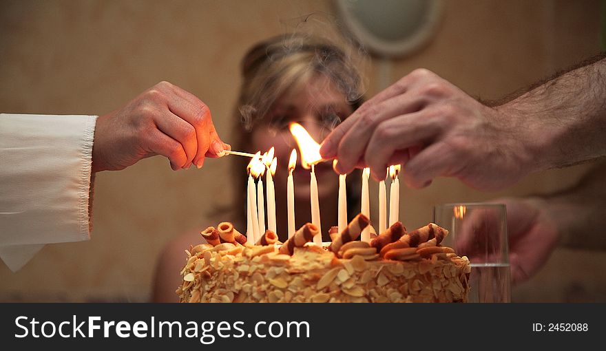 Sister and brother is lighting birthday cake candles