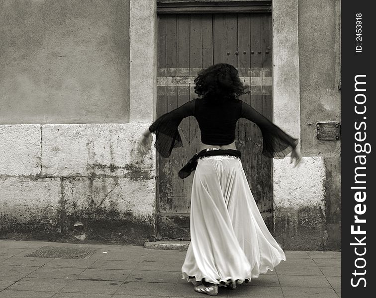 The back of a belly dancer as she dances in the street. The back of a belly dancer as she dances in the street