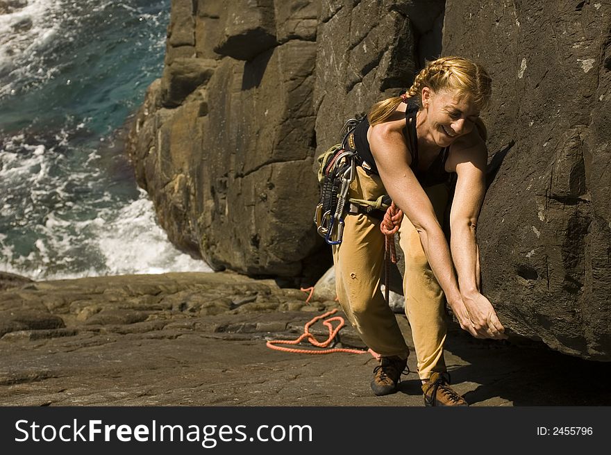 Woman climbing a large crack in a sea cliff. Woman climbing a large crack in a sea cliff