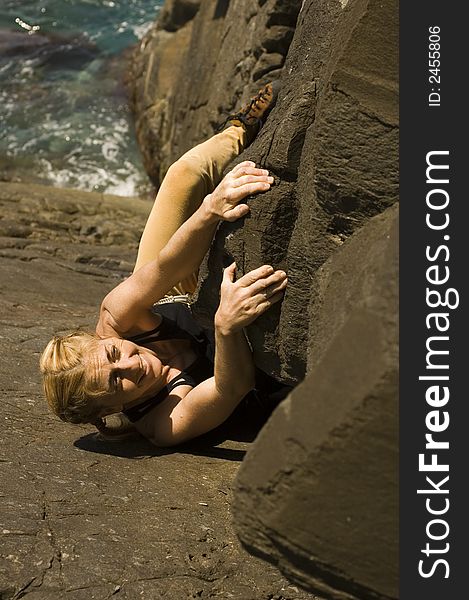Woman climbing a sea cliff in Okinawa Japan. Woman climbing a sea cliff in Okinawa Japan