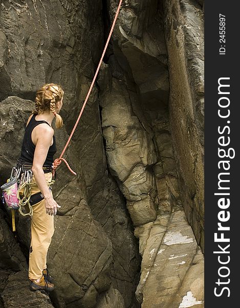 A woman preparing to climb a sea cliff. A woman preparing to climb a sea cliff