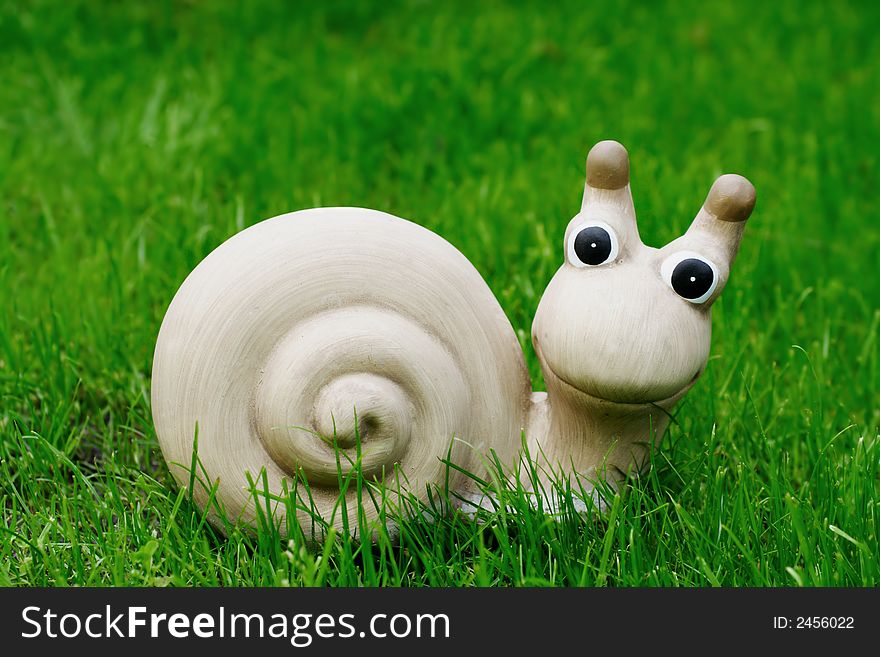 Ceramic snail in the grass, outdoor