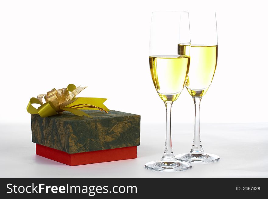 View of packed present and two glasses of white wine. View of packed present and two glasses of white wine