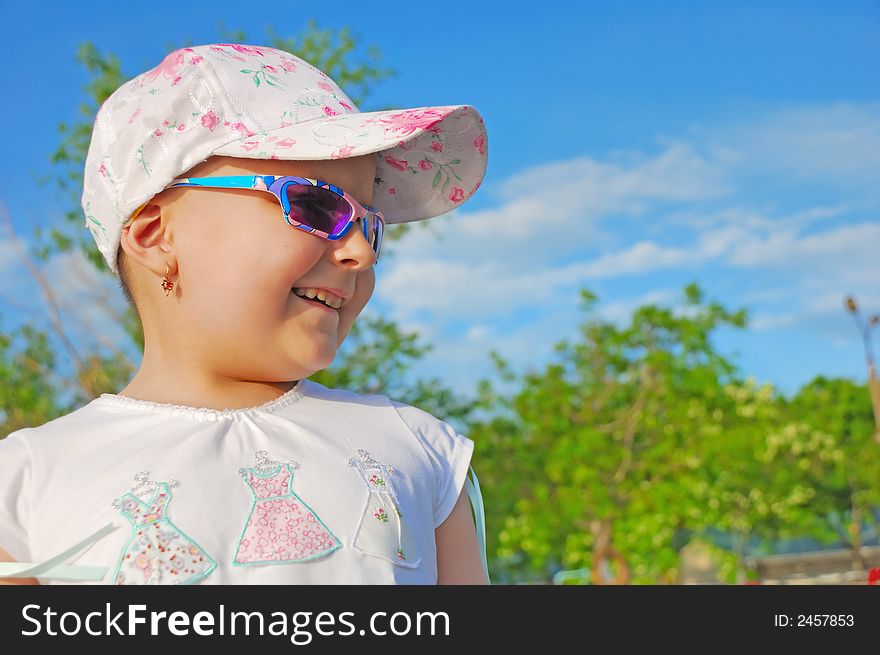 Laughing kid on cloudy sky background