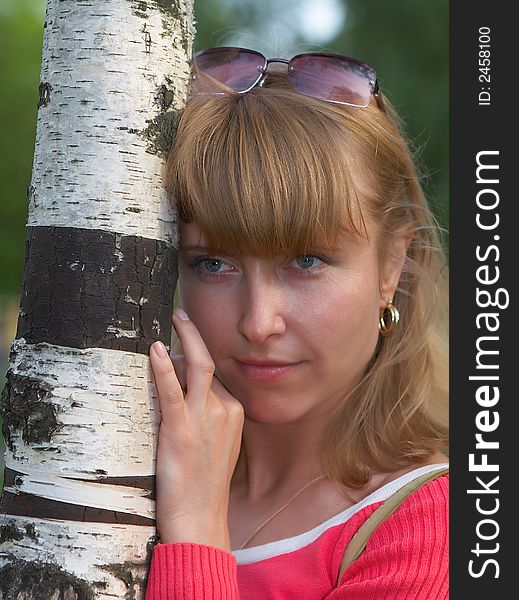 Portrait of the young beautiful girl near to a trunk of a birch. Portrait of the young beautiful girl near to a trunk of a birch