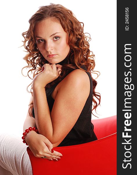 Attractive red hair girl sitting on modern red armchair. Attractive red hair girl sitting on modern red armchair.