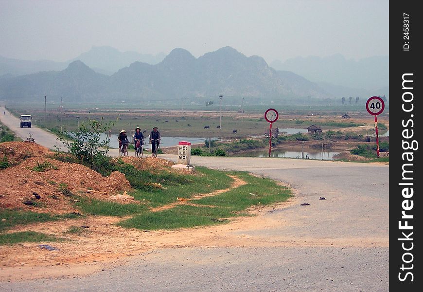 Three workers riding home on National Highway 1, Central Vietnam. Three workers riding home on National Highway 1, Central Vietnam