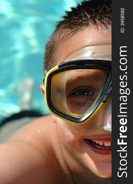 Boy in diving mask in the water; half face composition to allow for copy space. Boy in diving mask in the water; half face composition to allow for copy space