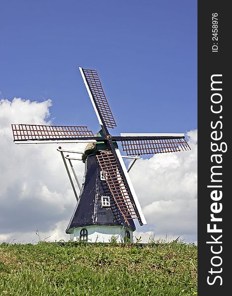 Old dutch windmill in the countryside in the Netherlands against a blue sky