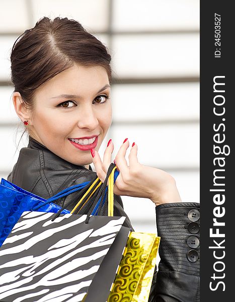 Portrait of beautiful caucasian brunette woman with colorful shopping bags. Portrait of beautiful caucasian brunette woman with colorful shopping bags