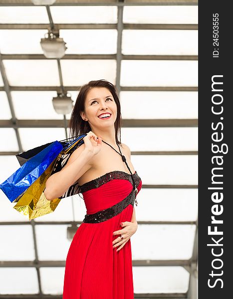 Portrait of beautiful caucasian brunette woman with colorful shopping bags