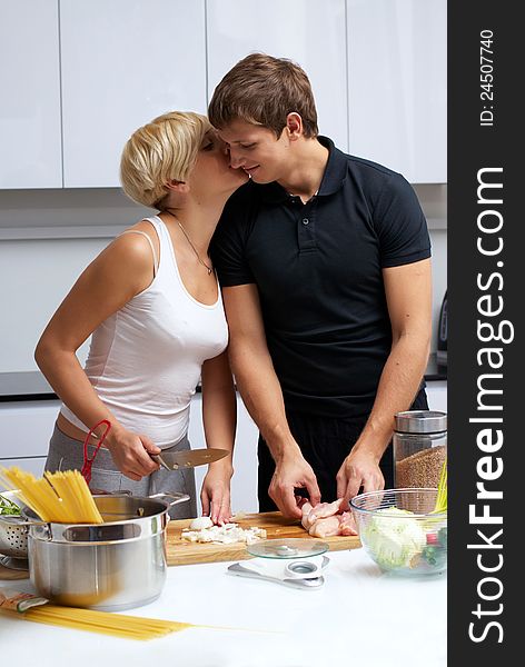 Playful young couple in their kitchen making dinner