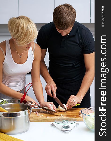 Playful young couple in their kitchen making dinner