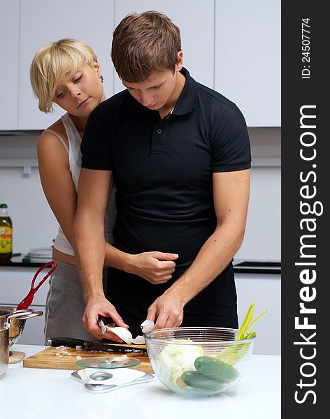 Playful young couple in their kitchen making dinner