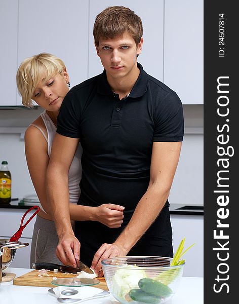 Playful young couple in their kitchen making dinner